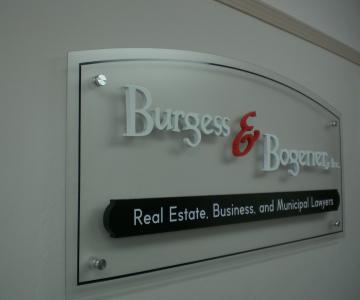 Interior sign with acrylic panel and added Gemini brand dimensional letters and aluminum standoffs to attach to drywall.