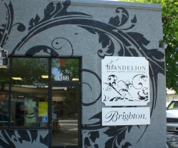 Hand painted flourish pattern on stucco wall.  Signs are MDO custom shaped with prints and cut vinyl decoration.